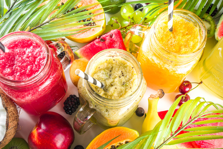 A variety of vibrant tropical smoothies in mason jars, surrounded by exotic fruits like watermelon, papaya, and kiwi for a nutritious, summery treat.