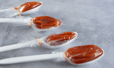 Close-up shot of plastic spoons each filled with soft, tangy tamarind candy wrapped in cellophane. These individually portioned spoons capture the sweet-and-sour flavor prized in many Mexican candies