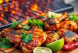 Grilled Pollo Asado with a golden, charred crust, garnished with fresh cilantro and lime wedges, sizzling on a wooden board near an open grill.
