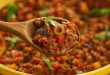 Traditional Puerto Rican picadillo served in a skillet, featuring seasoned ground beef, green olives, and sofrito, garnished with fresh herbs