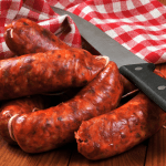 Fresh raw Spanish chorizo sausages on a rustic wooden table, highlighting the best ingredients and tips on how to cook chorizo to perfection.