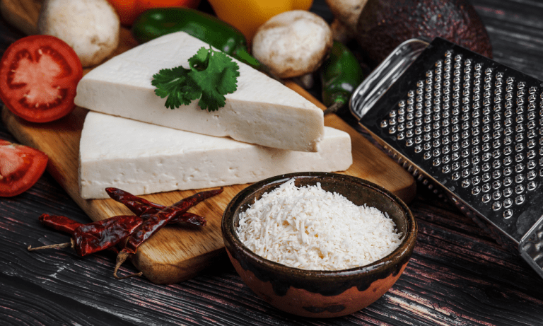 A single shot focusing on grated cotija cheese, illustrating what is cotija cheese in detail, while also hinting at a cotija cheese substitute for those curious about cojita cheese alternatives.